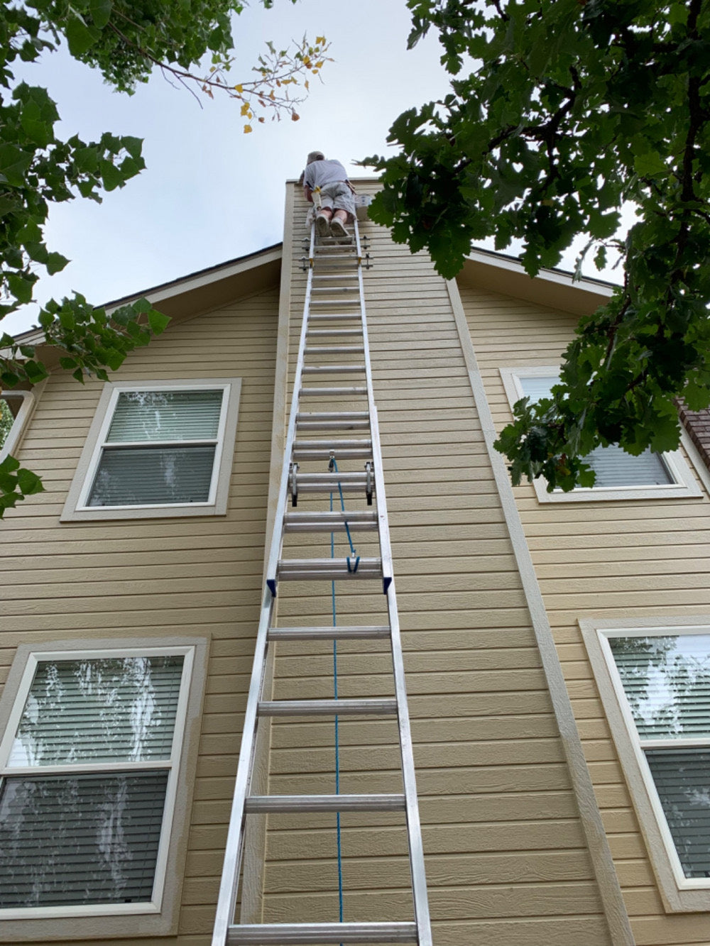 Bill's Painting crew member painting a second story