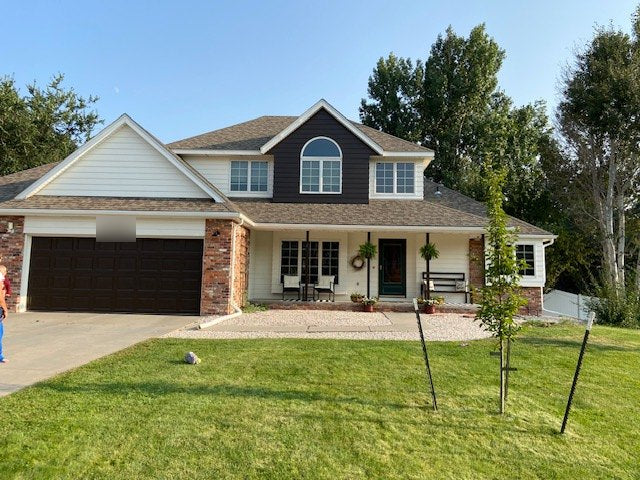 Finished white two-story home with dark accent gable